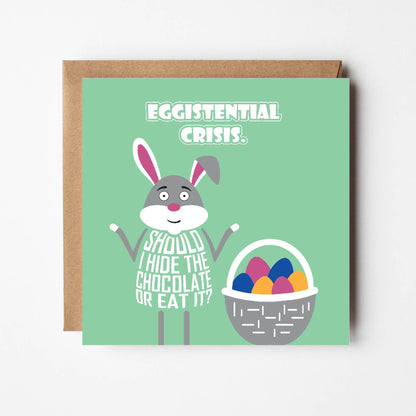 Card titled Eggistential Crisis in white text on green background.  Easter bunny stands next to basket of eggs asking Shall I hide the chocolate or eat it?  Card 150mm square supplied with eco-Kraft envelope.